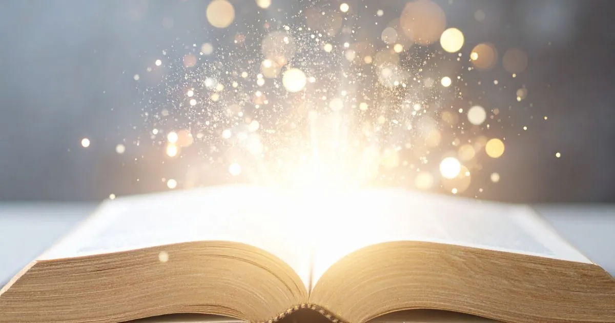 Open book with magic sparkles and light coming out