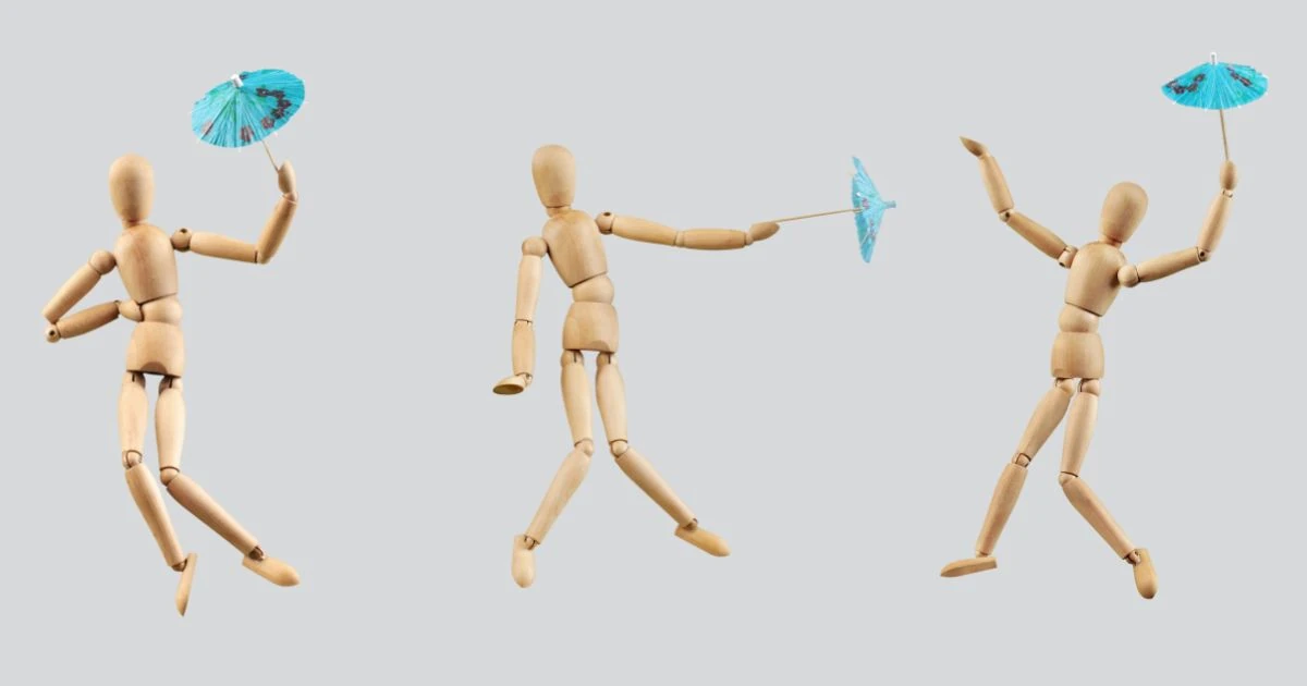 three wooden figurines in movement, each holding a blue cocktail umbrella